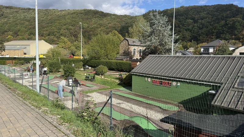 Le mini-golf vu depuis la rue, avec les pistes et le bâtiment vert